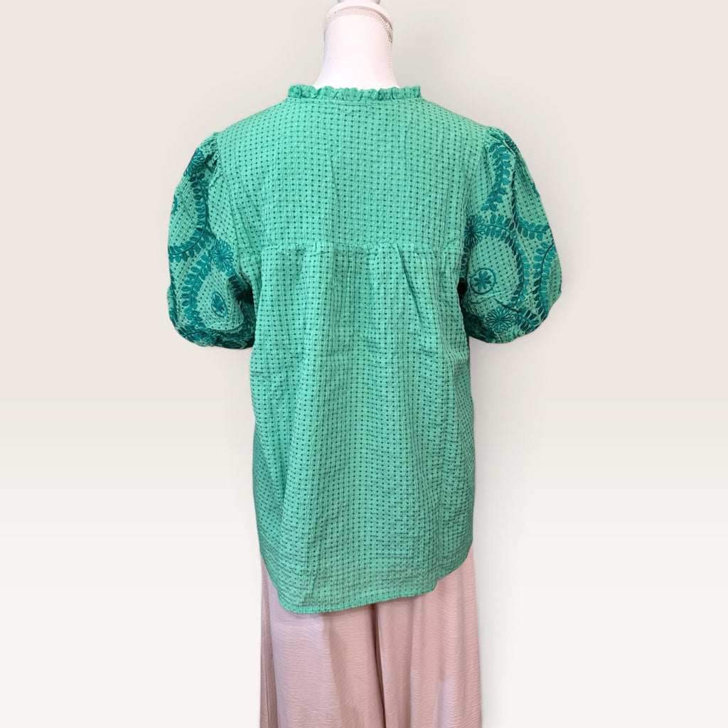 Back view of green textured blouse with embroidered sleeves
