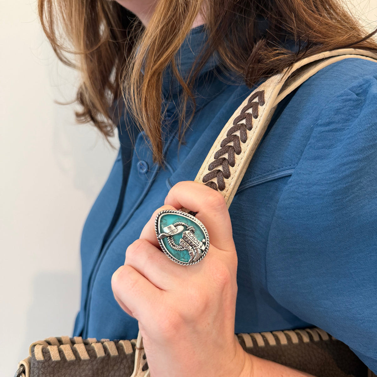 Model wearing the Myra High Noon Cowboy Hat Ring, featuring a silver-tone Western design with turquoise accents.