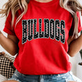 Woman wearing a red Comfort Colors Bulldogs graphic tee with black and white varsity lettering and denim shorts.