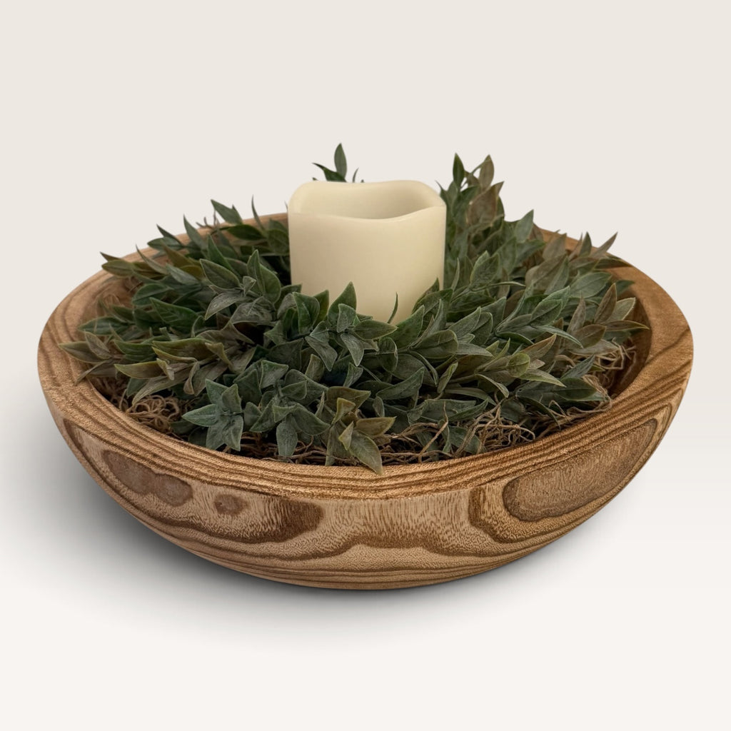 Round carved wood bowl centerpiece with faux ruscus greenery and LED candle