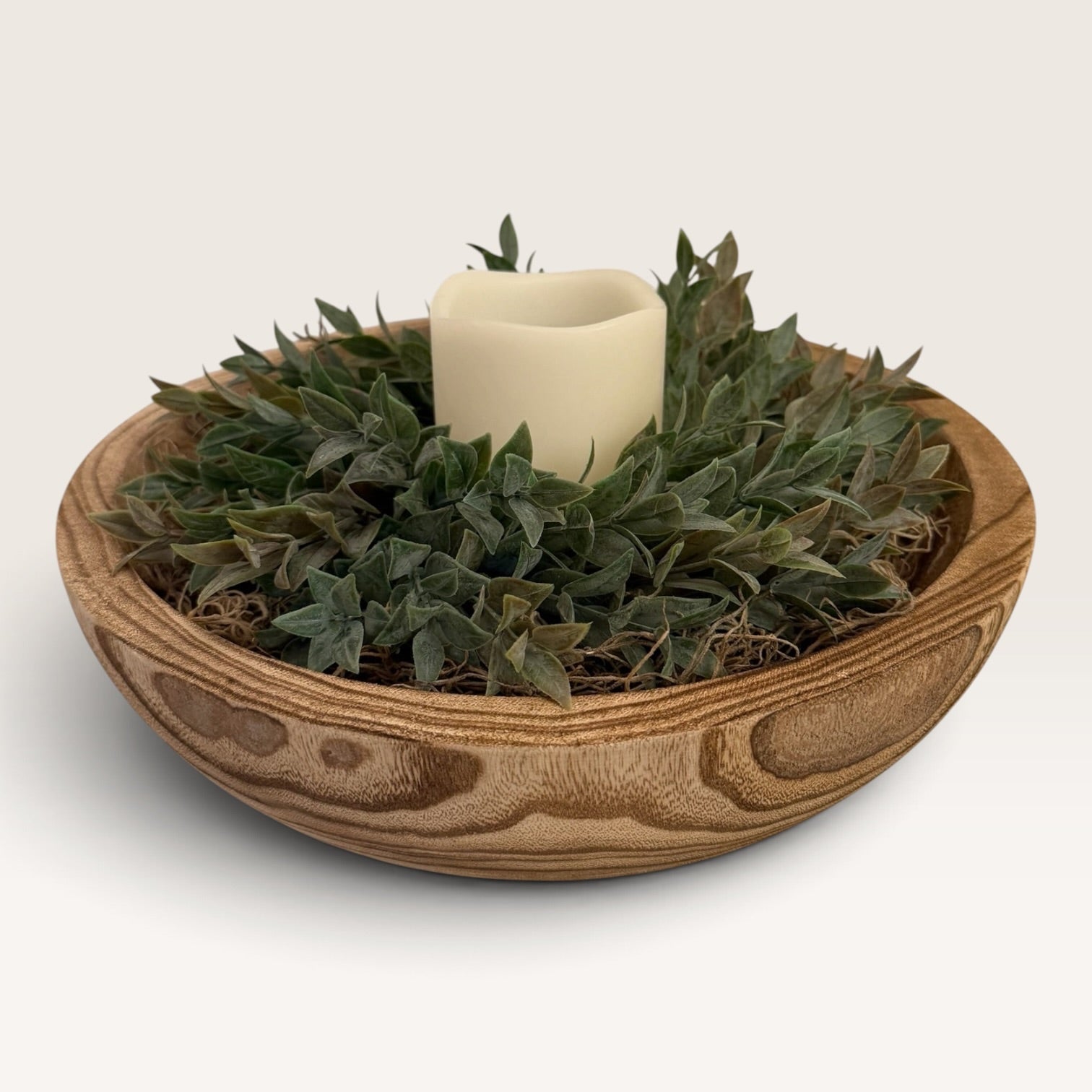 Round carved wood bowl centerpiece with faux ruscus greenery and LED candle