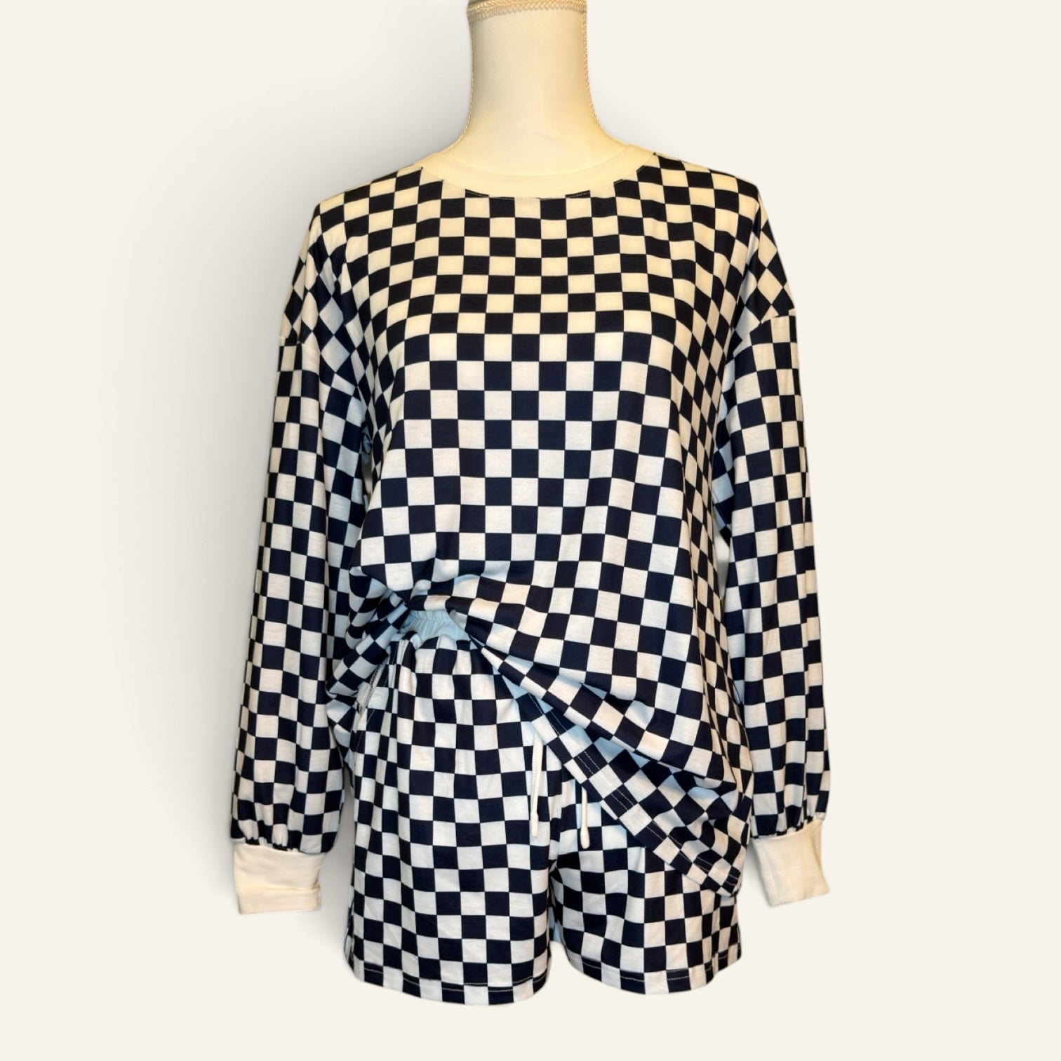 Front view of navy and white checkered long-sleeve top and shorts set