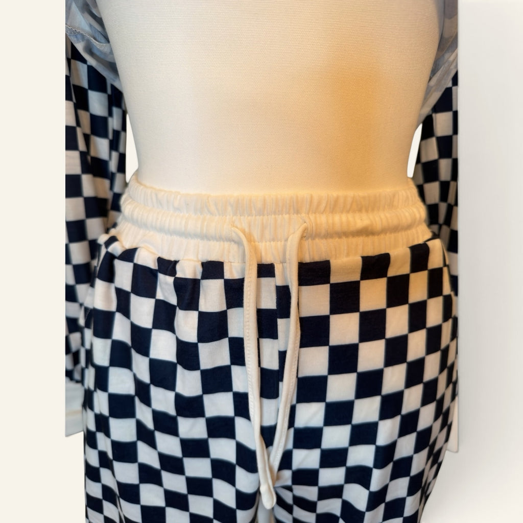 Close-up of drawstring waistband on navy and white checkered shorts