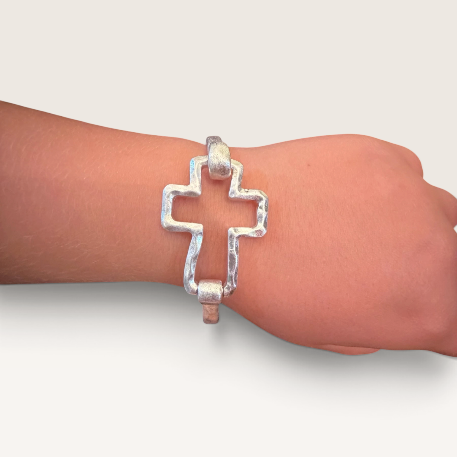 Red Clay Mercantile silver hammered cross bracelet with an open-frame design worn on a wrist